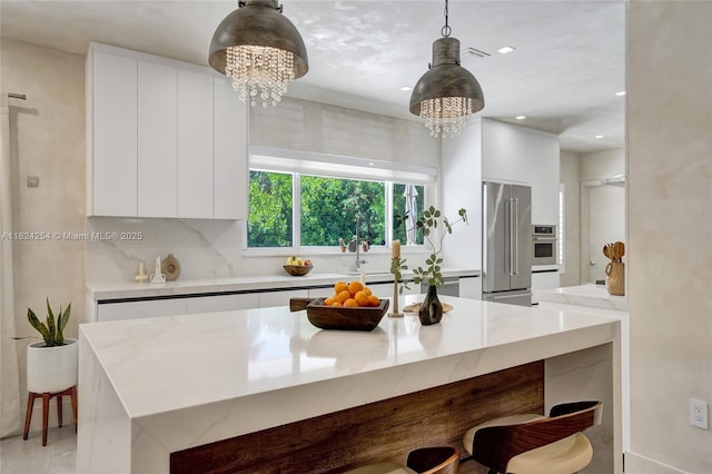 1330 Harrison St, Hollywood, FL 33019 - kitchen featuring appliances with stainless steel finishes, modern cabinets, a chandelier, a kitchen bar, and white cabinets