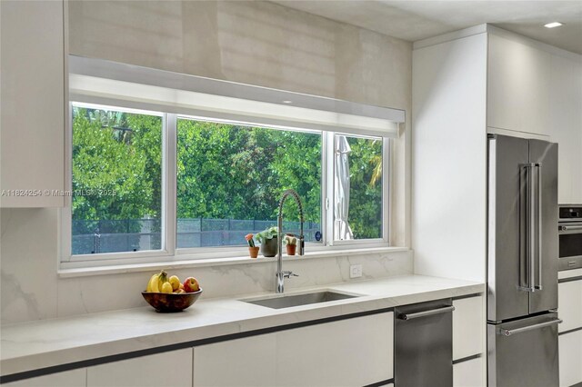 1330 Harrison St, Hollywood, FL 33019 - kitchen with high end refrigerator, white cabinets, recessed lighting, and modern cabinets