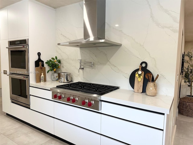 1330 Harrison St, Hollywood, FL 33019 - kitchen with wall chimney range hood, appliances with stainless steel finishes, backsplash, white cabinetry, and modern cabinets