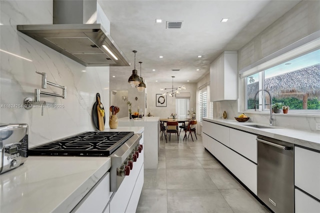 1330 Harrison St, Hollywood, FL 33019 - kitchen featuring exhaust hood, appliances with stainless steel finishes, white cabinetry, modern cabinets, and hanging light fixtures