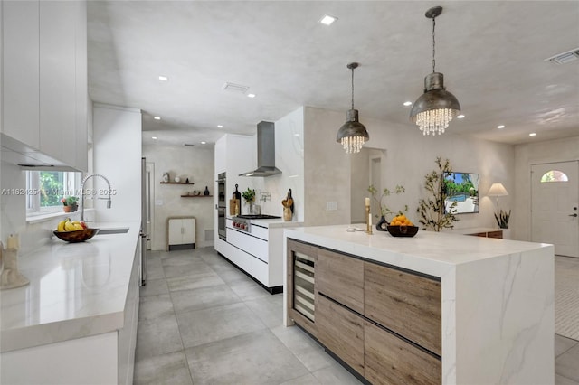 1330 Harrison St, Hollywood, FL 33019 - kitchen with wall chimney exhaust hood, modern cabinets, a chandelier, recessed lighting, and white cabinetry