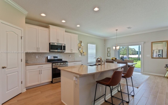 365 Cedarstone Way, Saint Augustine, FL 32092 - kitchen featuring appliances with stainless steel finishes, backsplash, white cabinets, light wood-style floors, and ornamental molding