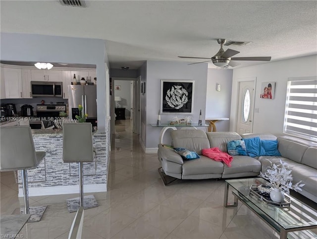 1206 Archdale St, Lehigh Acres, FL 33936 - living area with ceiling fan and a textured ceiling