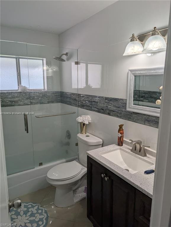 1206 Archdale St, Lehigh Acres, FL 33936 - bathroom with vanity, enclosed tub / shower combo, tile patterned floors, and tile walls