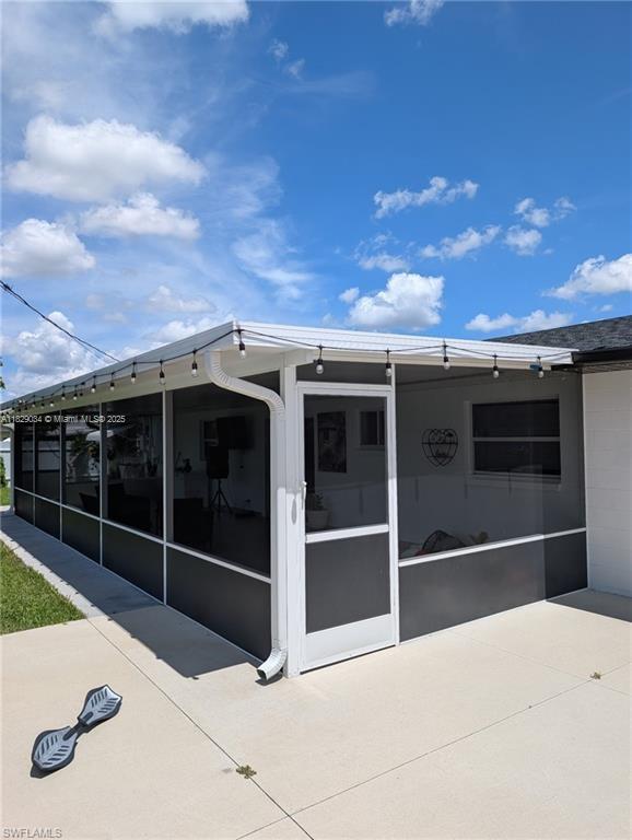 1206 Archdale St, Lehigh Acres, FL 33936 - back of house featuring a sunroom