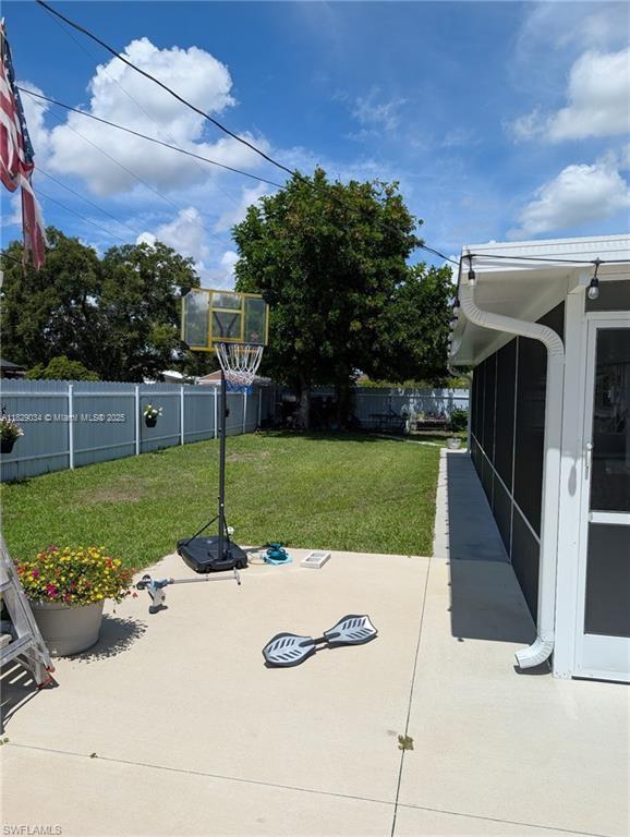 1206 Archdale St, Lehigh Acres, FL 33936 - fenced backyard with a patio and a sunroom