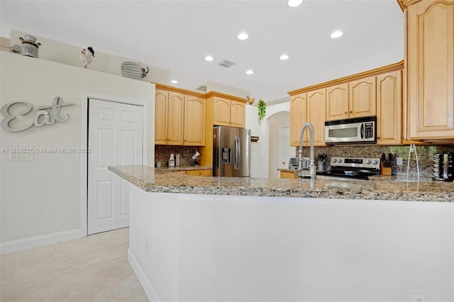 12851 Luray Rd, Southwest Ranches, FL 33330 - kitchen with stainless steel appliances, recessed lighting, light stone counters, a peninsula, and light brown cabinets