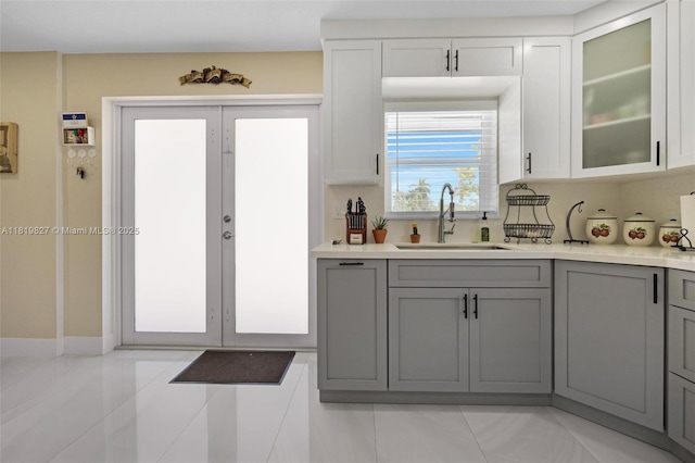 12851 Luray Rd, Southwest Ranches, FL 33330 - kitchen with gray cabinetry, light countertops, glass insert cabinets, and light tile patterned flooring