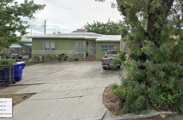 1710 SW 13th St, Miami, FL 33145 - view of front facade featuring a chimney, concrete driveway, and stucco siding