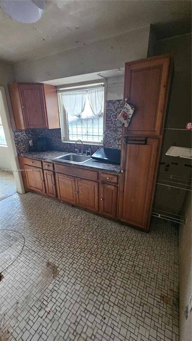 1710 SW 13th St, Miami, FL 33145 - kitchen featuring plenty of natural light, dark countertops, decorative backsplash, and brown cabinetry
