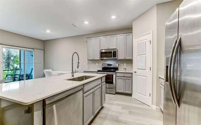 42 Appleton Ct, Saint Augustine, FL 32092 - kitchen featuring stainless steel appliances, gray cabinets, a center island with sink, recessed lighting, and light stone countertops