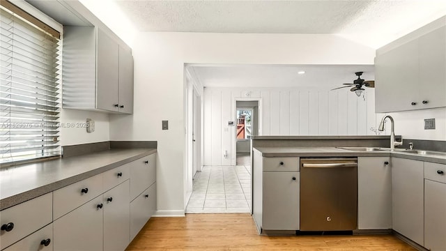1482 SE Manth Ln, Port St Lucie, FL 34983 - kitchen with stainless steel dishwasher, dark countertops, ceiling fan, gray cabinetry, and a textured ceiling