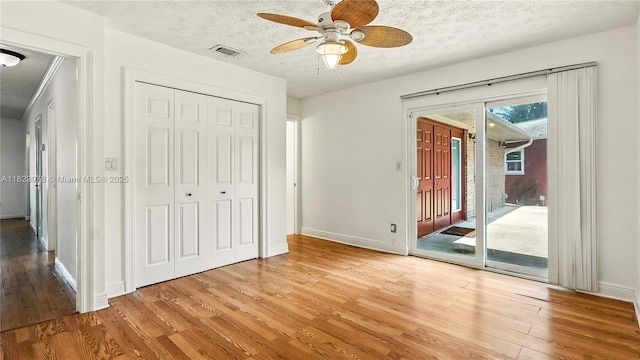 1482 SE Manth Ln, Port St Lucie, FL 34983 - unfurnished bedroom featuring access to outside, light wood-type flooring, a closet, a textured ceiling, and a ceiling fan