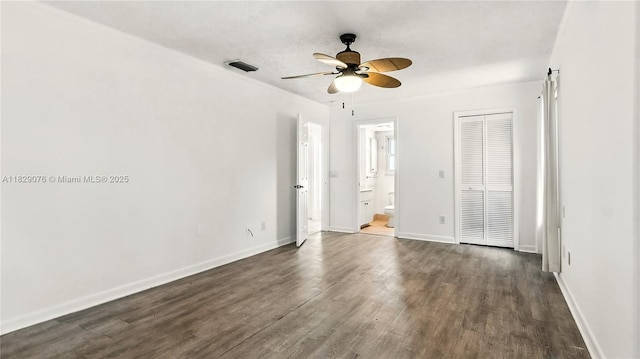 1482 SE Manth Ln, Port St Lucie, FL 34983 - unfurnished bedroom featuring dark wood-type flooring, connected bathroom, a closet, and ceiling fan