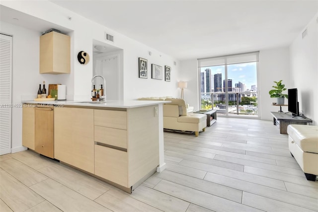 4250 Biscayne Blvd Unit 1217, Miami, FL 33137 - kitchen featuring open floor plan, light brown cabinetry, a wall of windows, a peninsula, and light countertops