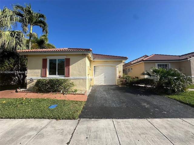 17253 NW 6th Ct, Pembroke Pines, FL 33029 - view of front of house featuring an attached garage, stucco siding, a tile roof, and driveway