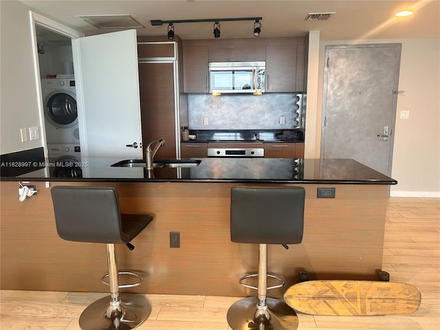 50 Biscayne Blvd Unit 4706, Miami, FL 33132 - kitchen with stainless steel microwave, dark countertops, a breakfast bar area, tasteful backsplash, and wall oven