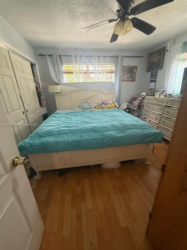 7900 SW 21st Ter, Miami, FL 33155 - bedroom with wood finished floors, a textured ceiling, a closet, and a ceiling fan
