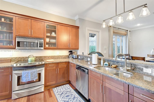 1110 SE 4th Ave, Fort Lauderdale, FL 33316 - kitchen with stainless steel appliances, ornamental molding, light stone counters, brown cabinetry, and light wood-type flooring