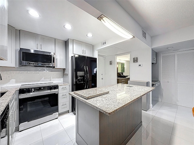 101 E Mcnab Rd Unit 311, Pompano Beach, FL 33060 - kitchen featuring stainless steel microwave, electric range oven, light tile patterned floors, light stone countertops, and recessed lighting