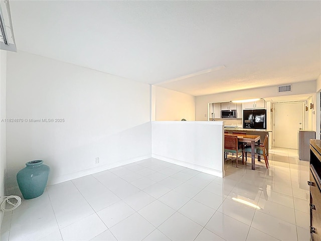 101 E Mcnab Rd Unit 311, Pompano Beach, FL 33060 - unfurnished living room with light tile patterned floors and baseboards