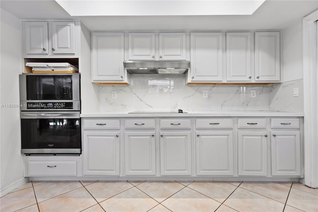 16400 SW 80th Ave, Palmetto Bay, FL 33157 - kitchen featuring black appliances, under cabinet range hood, light countertops, light tile patterned floors, and tasteful backsplash
