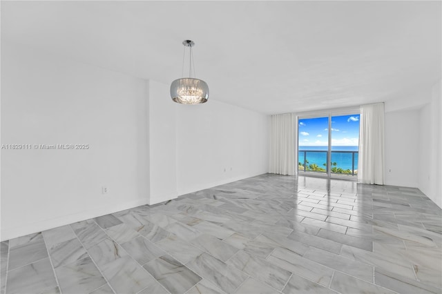 10275 Collins Ave Unit 1035, Bal Harbour, FL 33154 - unfurnished room featuring floor to ceiling windows, a chandelier, and a water view