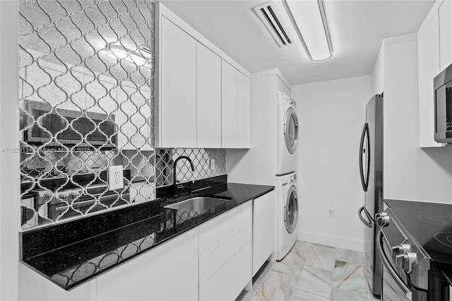 10275 Collins Ave Unit 1035, Bal Harbour, FL 33154 - laundry area featuring stacked washer and clothes dryer and light marble finish floors