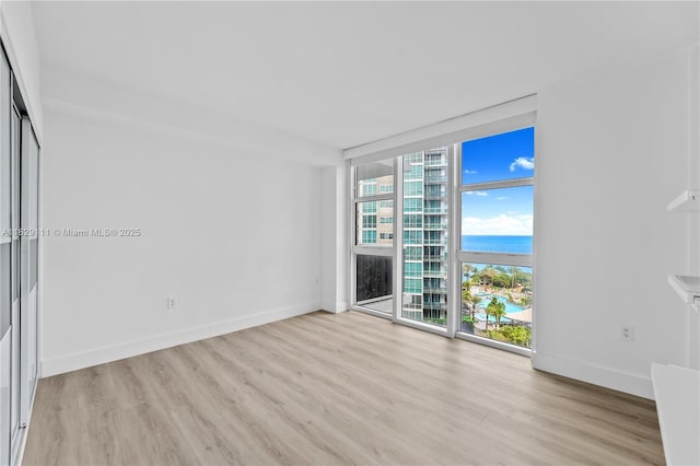 10275 Collins Ave Unit 1035, Bal Harbour, FL 33154 - unfurnished room with a wall of windows, light wood-style flooring, and a water view