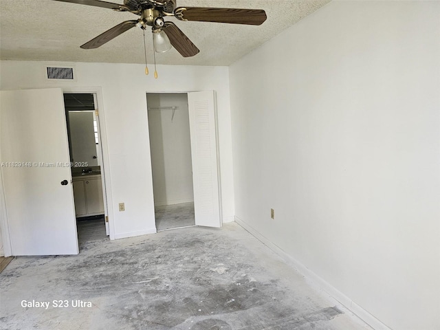 907 NE 199th St Unit 106, Miami, FL 33179 - unfurnished bedroom featuring concrete flooring, a textured ceiling, a closet, and a ceiling fan