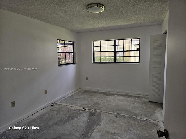 907 NE 199th St Unit 106, Miami, FL 33179 - unfurnished room featuring a textured ceiling and concrete flooring