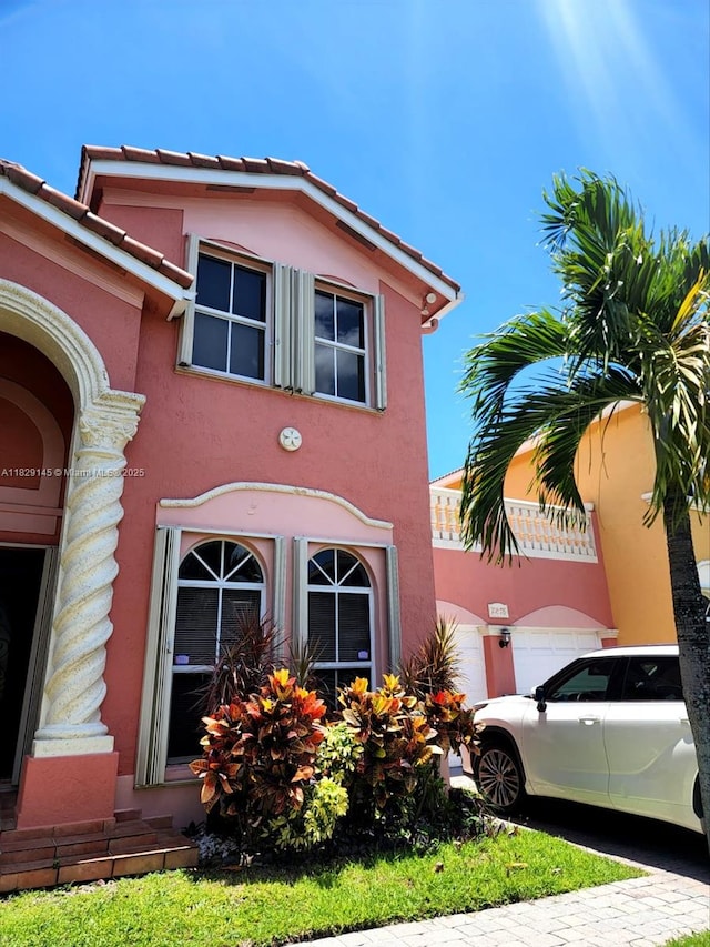 10878 NW 51st Ln, Doral, FL 33178 - view of side of property featuring stucco siding, driveway, a garage, and a tiled roof