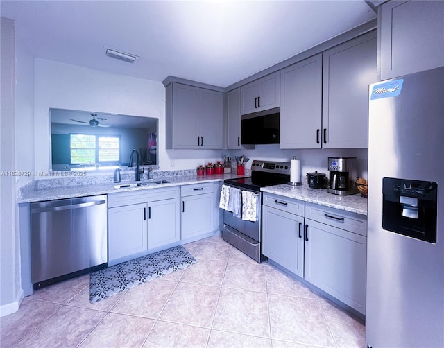 61 W Seminole Ct W, Royal Palm Beach, FL 33411 - kitchen featuring appliances with stainless steel finishes, gray cabinets, a ceiling fan, light tile patterned floors, and light stone counters