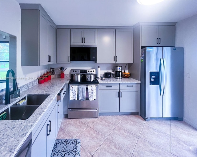 61 W Seminole Ct W, Royal Palm Beach, FL 33411 - kitchen with appliances with stainless steel finishes, gray cabinets, light tile patterned flooring, and light stone countertops