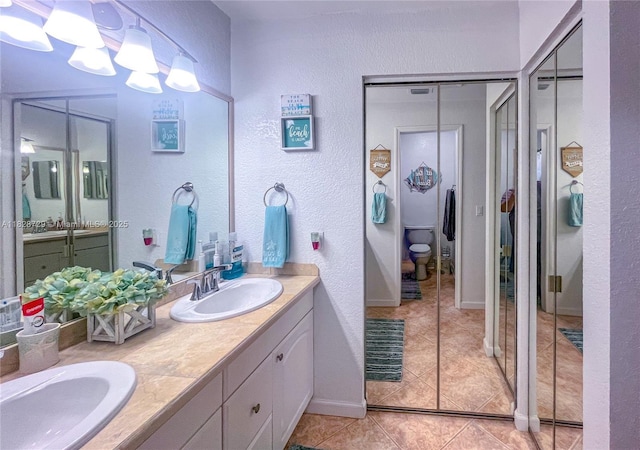 61 W Seminole Ct W, Royal Palm Beach, FL 33411 - full bathroom featuring double vanity, tile patterned floors, and a textured wall