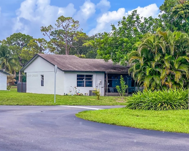 61 W Seminole Ct W, Royal Palm Beach, FL 33411 - view of front facade with stucco siding, a front lawn, and a shingled roof