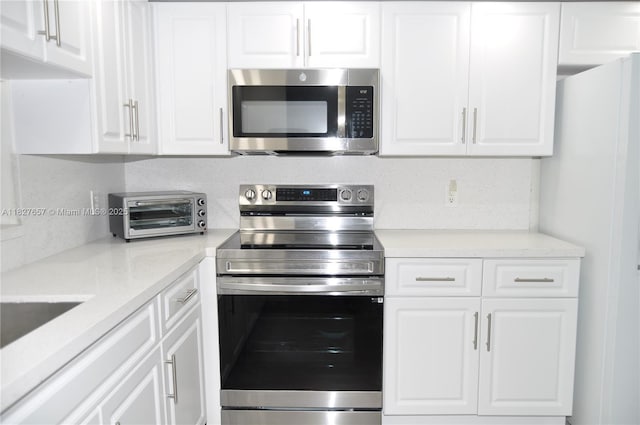 700 SW 128th Ave Unit 106C, Pembroke Pines, FL 33027 - kitchen with stainless steel appliances, white cabinetry, and light countertops