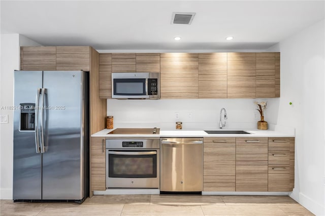 121 NE 34th St Unit 1514, Miami, FL 33137 - kitchen with appliances with stainless steel finishes, light countertops, brown cabinets, and recessed lighting
