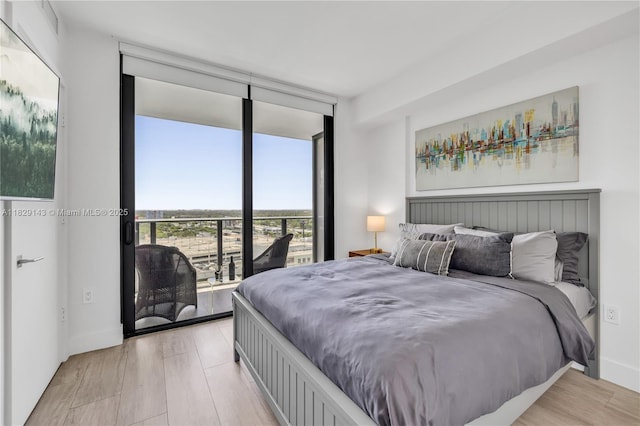 121 NE 34th St Unit 1514, Miami, FL 33137 - bedroom with light wood-type flooring, floor to ceiling windows, and access to outside