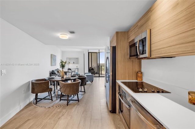 121 NE 34th St Unit 1514, Miami, FL 33137 - kitchen with stainless steel appliances, light wood-style floors, light countertops, brown cabinets, and modern cabinets