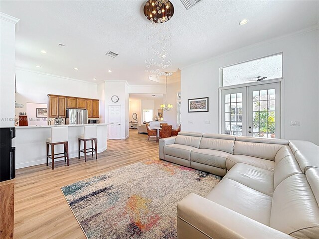 4268 SW 141st Ave, Davie, FL 33330 - living room featuring a chandelier, ornamental molding, light wood finished floors, a textured ceiling, and recessed lighting