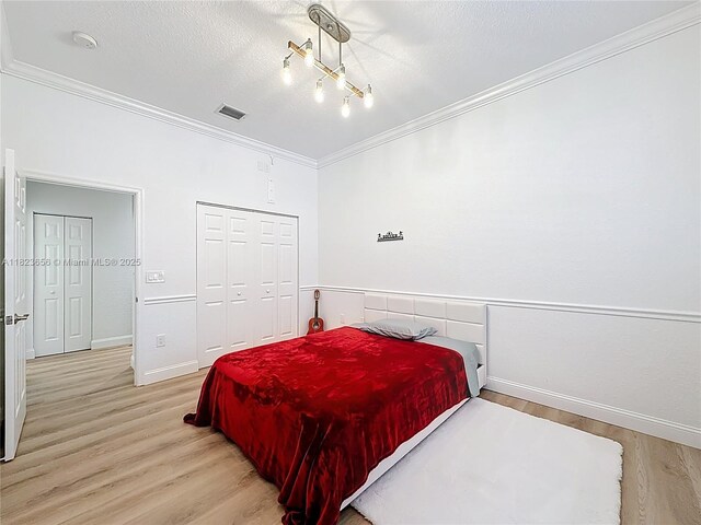 4268 SW 141st Ave, Davie, FL 33330 - bedroom with crown molding, light wood-style floors, a closet, and a textured ceiling