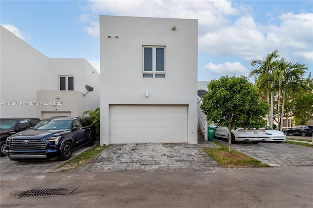 10555 NW 64th Way, Doral, FL 33178 - view of front of home featuring an attached garage, stucco siding, and decorative driveway
