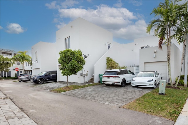10555 NW 64th Way, Doral, FL 33178 - view of property exterior featuring stucco siding, decorative driveway, and a garage
