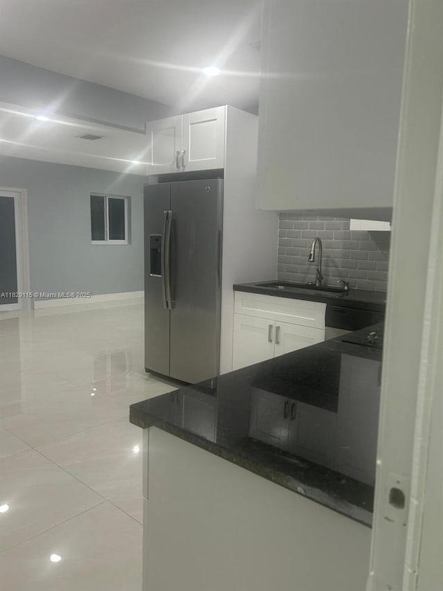 9020 NW 32nd Ave, Miami, FL 33147 - kitchen featuring stainless steel fridge with ice dispenser, backsplash, white cabinetry, and light tile patterned flooring