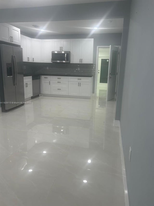 9020 NW 32nd Ave, Miami, FL 33147 - kitchen featuring stainless steel appliances, dark countertops, decorative backsplash, and white cabinets