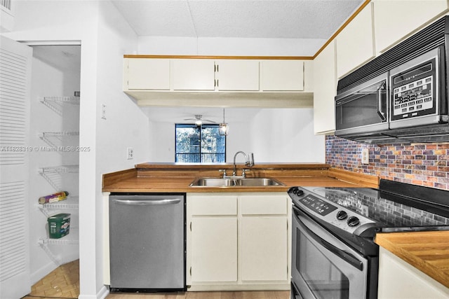 10501 W Broward Blvd Unit 304, Plantation, FL 33324 - kitchen with appliances with stainless steel finishes, backsplash, white cabinets, and wood counters
