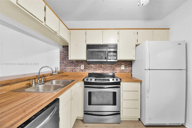 10501 W Broward Blvd Unit 304, Plantation, FL 33324 - kitchen with stainless steel appliances, light countertops, light wood-type flooring, decorative backsplash, and a textured ceiling