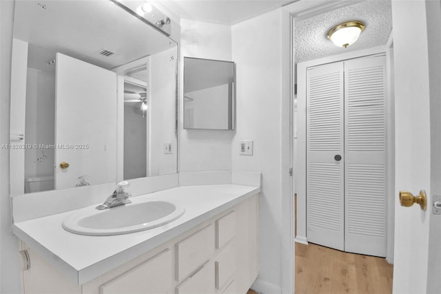 10501 W Broward Blvd Unit 304, Plantation, FL 33324 - bathroom featuring a closet, vanity, wood finished floors, and a textured ceiling