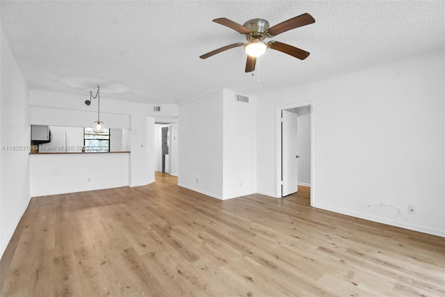 10501 W Broward Blvd Unit 304, Plantation, FL 33324 - unfurnished living room featuring a ceiling fan, wood finished floors, and a textured ceiling